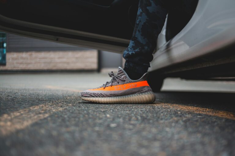 Close-up of stylish sneakers stepping out of a vehicle, highlighting urban fashion.